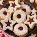a black plate on table full of Linzer Cookies with Jam Filling