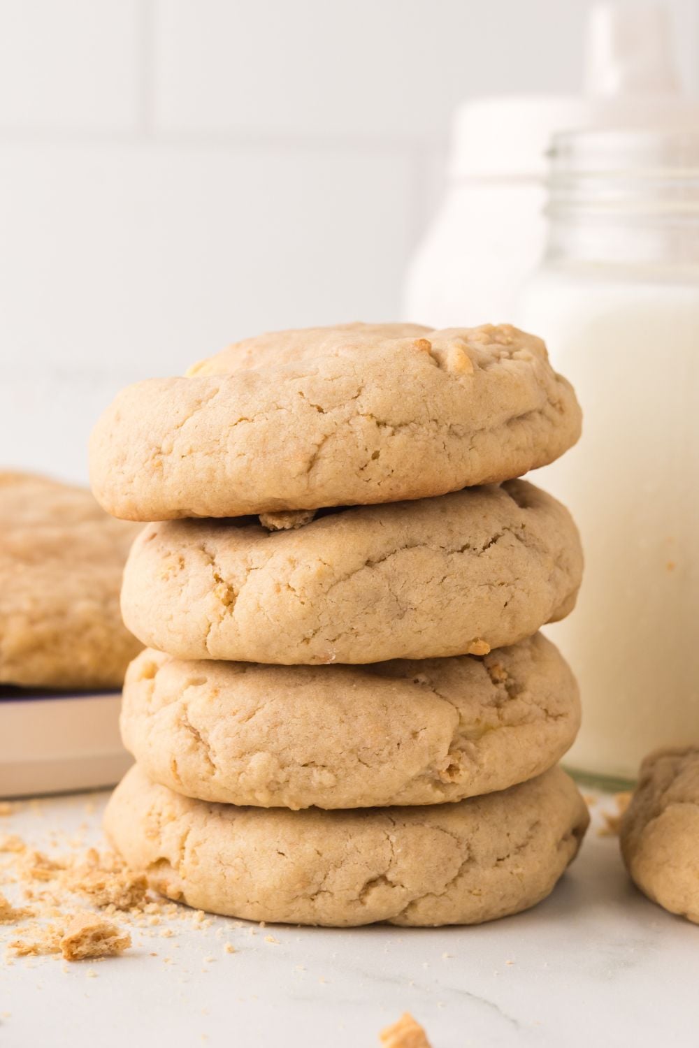 New York cheesecake cookies in a stack on table with a jar of milk behind it on table 