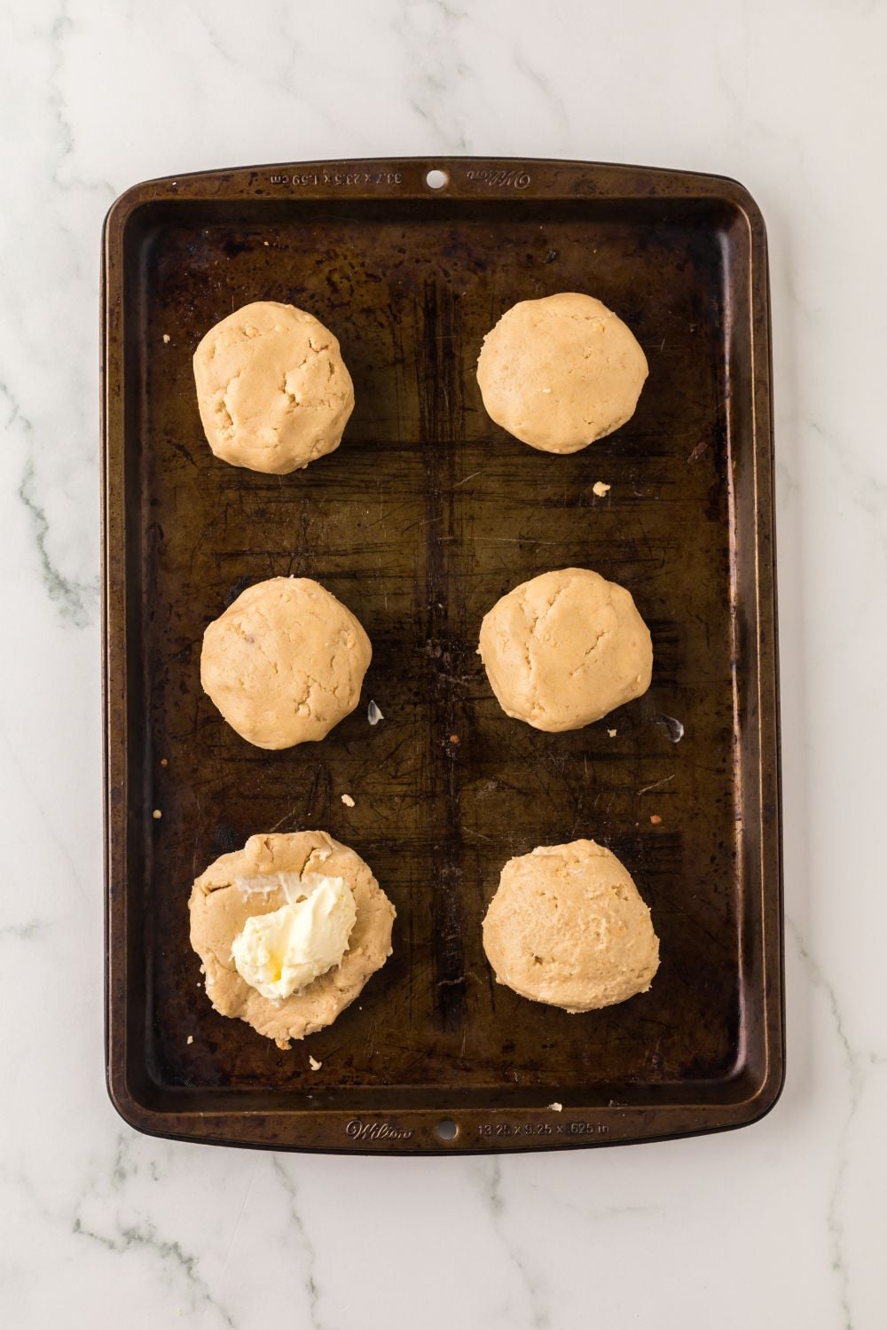 cheesecake cookie in raw dough on table with cheesecake in the center of table 
