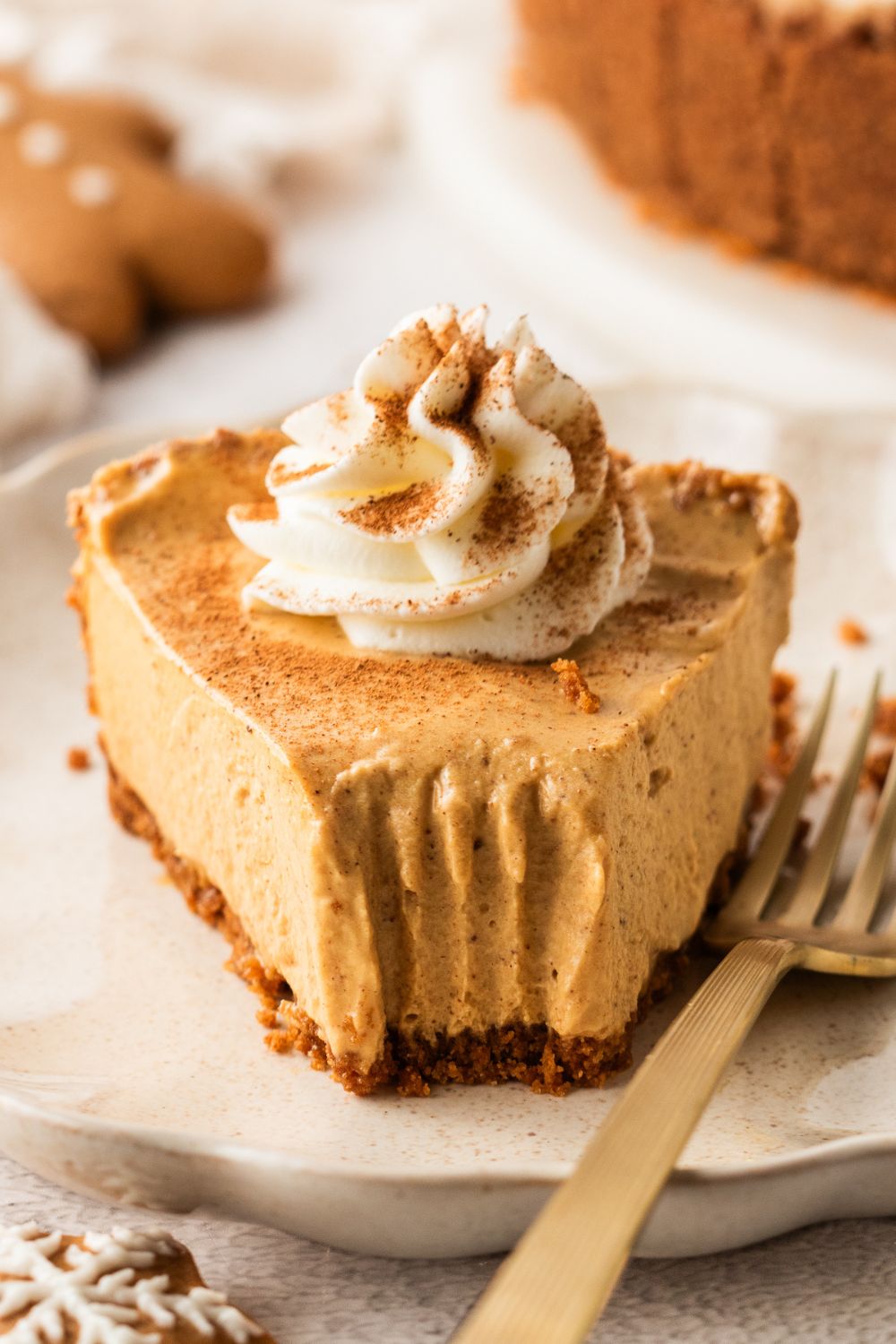 No Bake Gingerbread Cheesecake on a plate with a bite taken out of it 