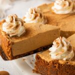 No Bake Gingerbread Cheesecake on a platter with one slice lifting out of the pie plate