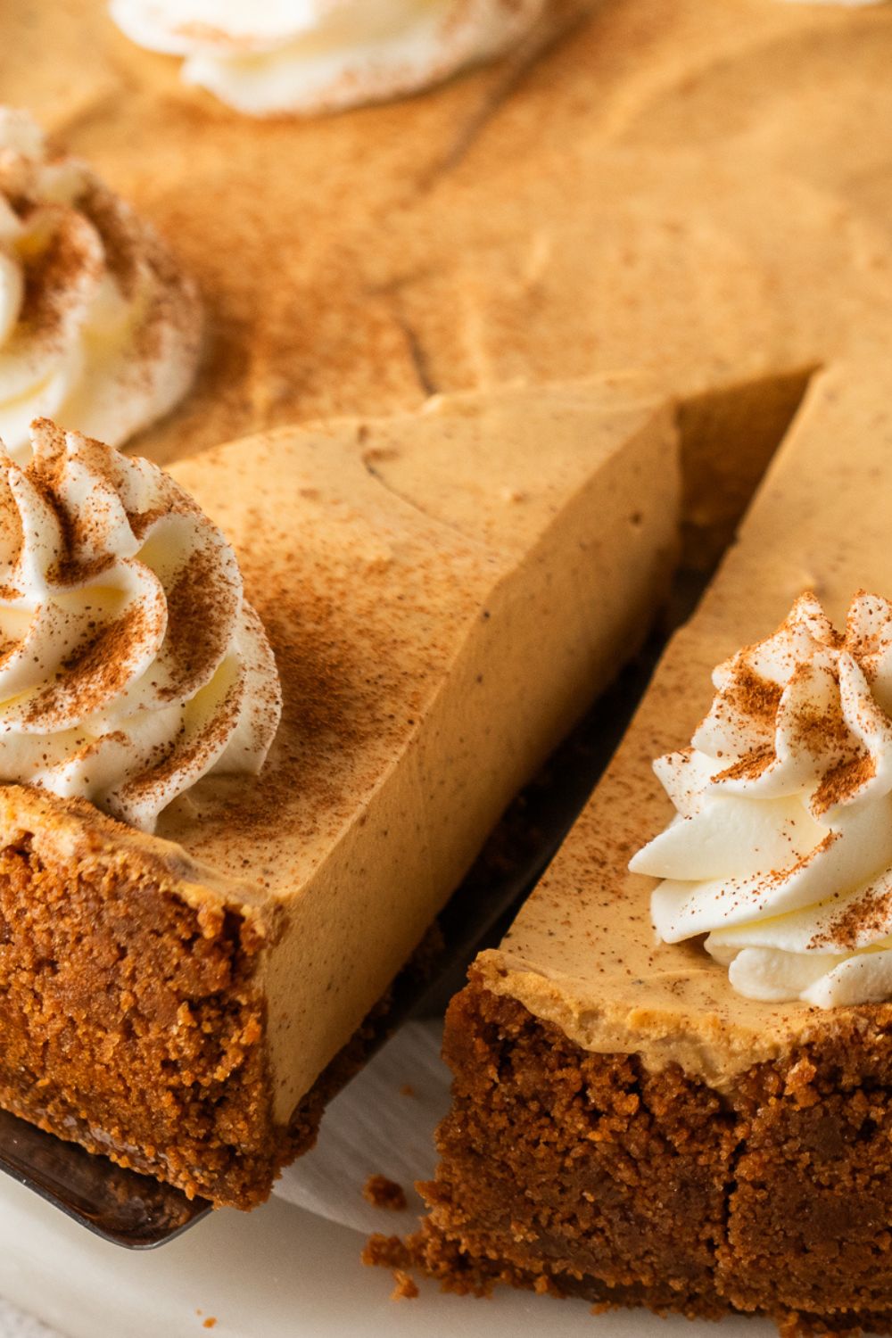 slice of No Bake Gingerbread Cheesecake being lifted off the pie plate 