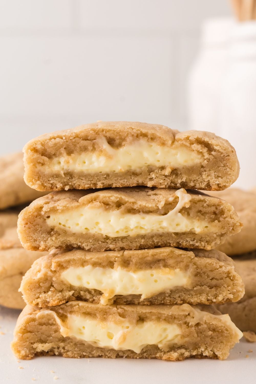 two cookies cut in half with cheesecake filling in each cookie on marble counter 