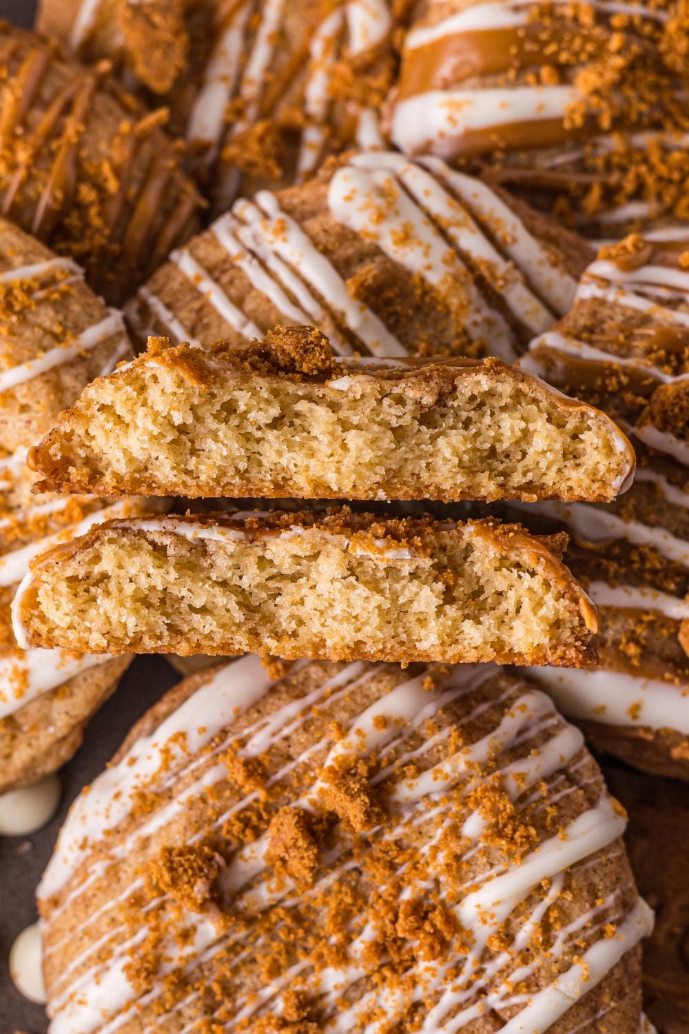 Biscoff Snickerdoodle Cookies spread around the table with one cookie broken in half to show the center of cookies 