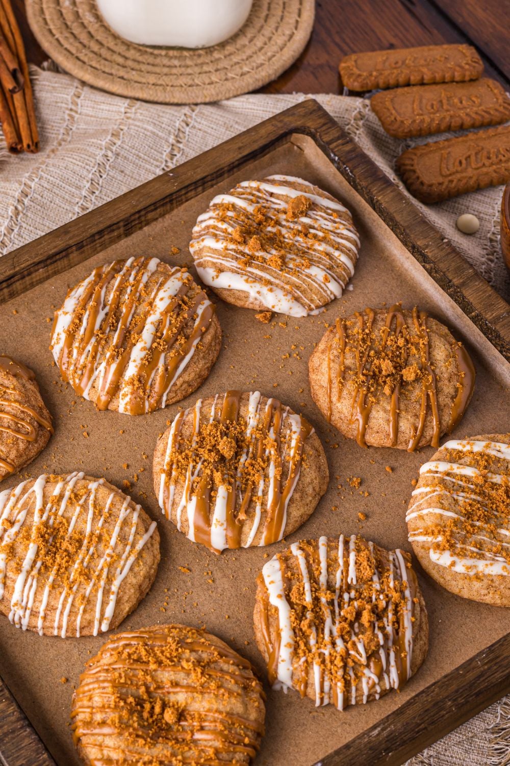 Biscoff Snickerdoodle Cookies on a baking sheet with cookies, milk and other items around the table 