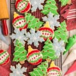 Decorated Sugar Cookies spread out on a table with rolling pin beside it and icing bags
