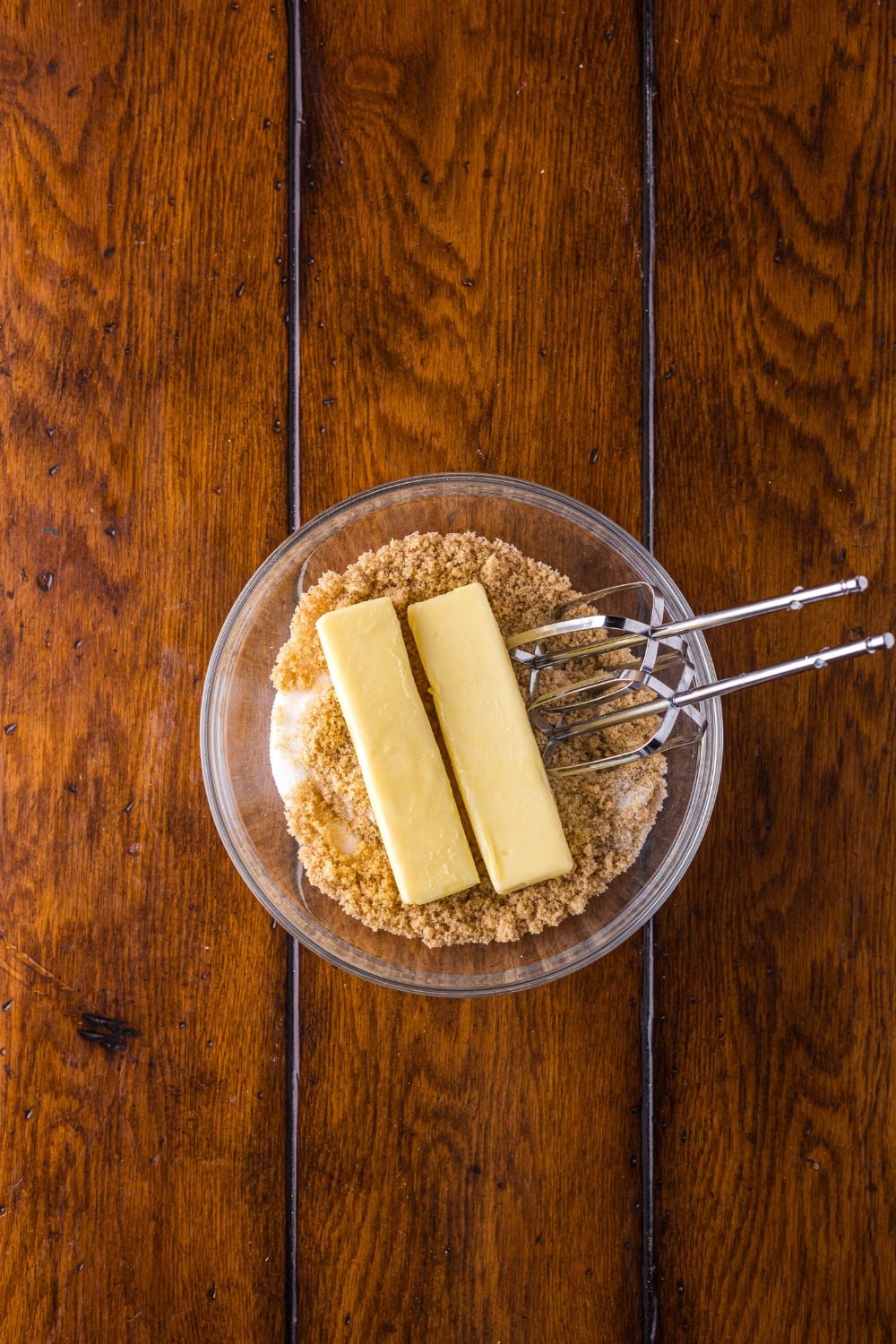 brown sugar and two sticks of butter with a glass bowl 