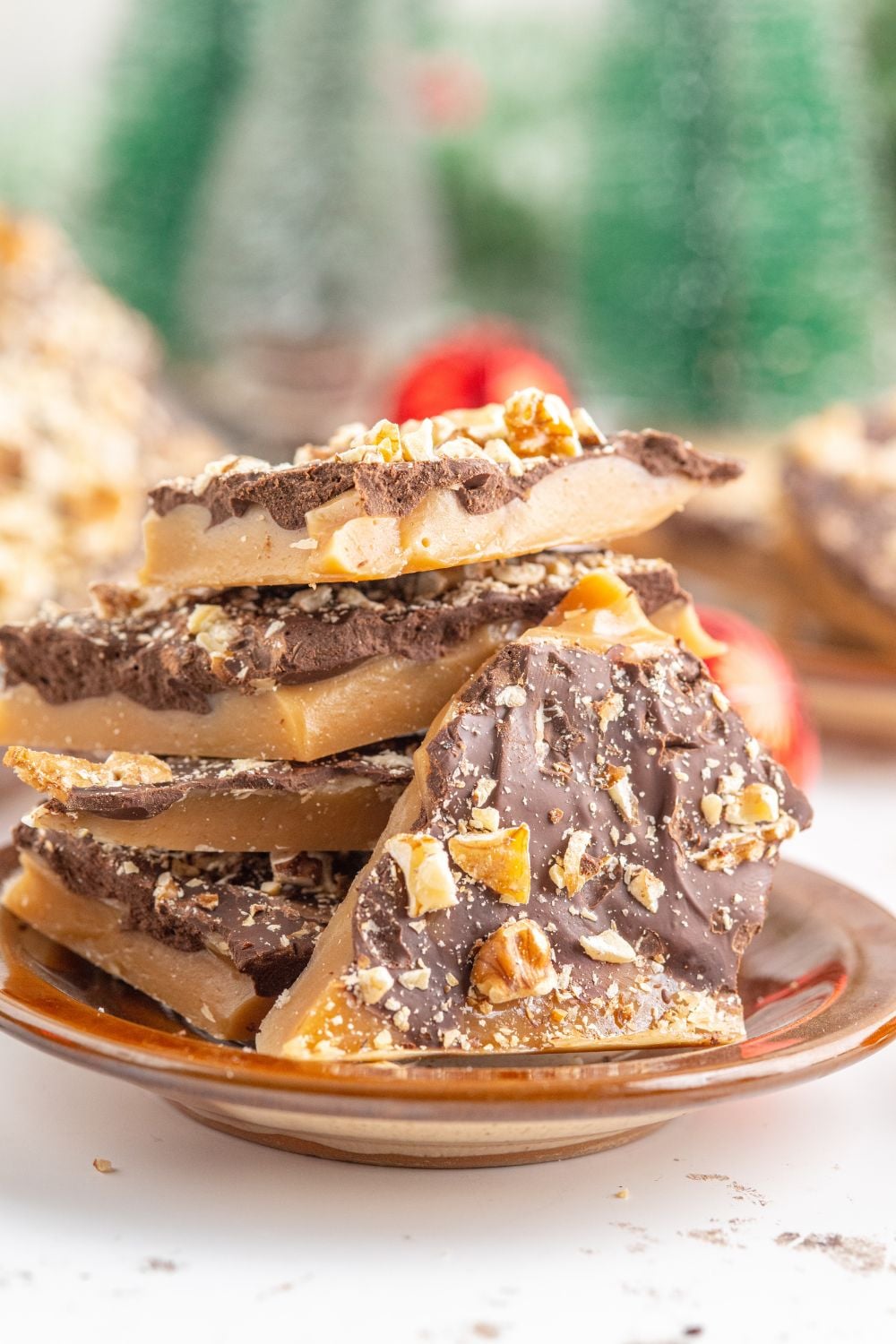 English Toffee on table with Christmas trees behind it on table 