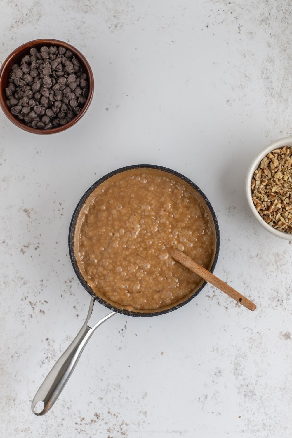 English Toffee being made in a saucepan with chocolate in a bowl to side on table 