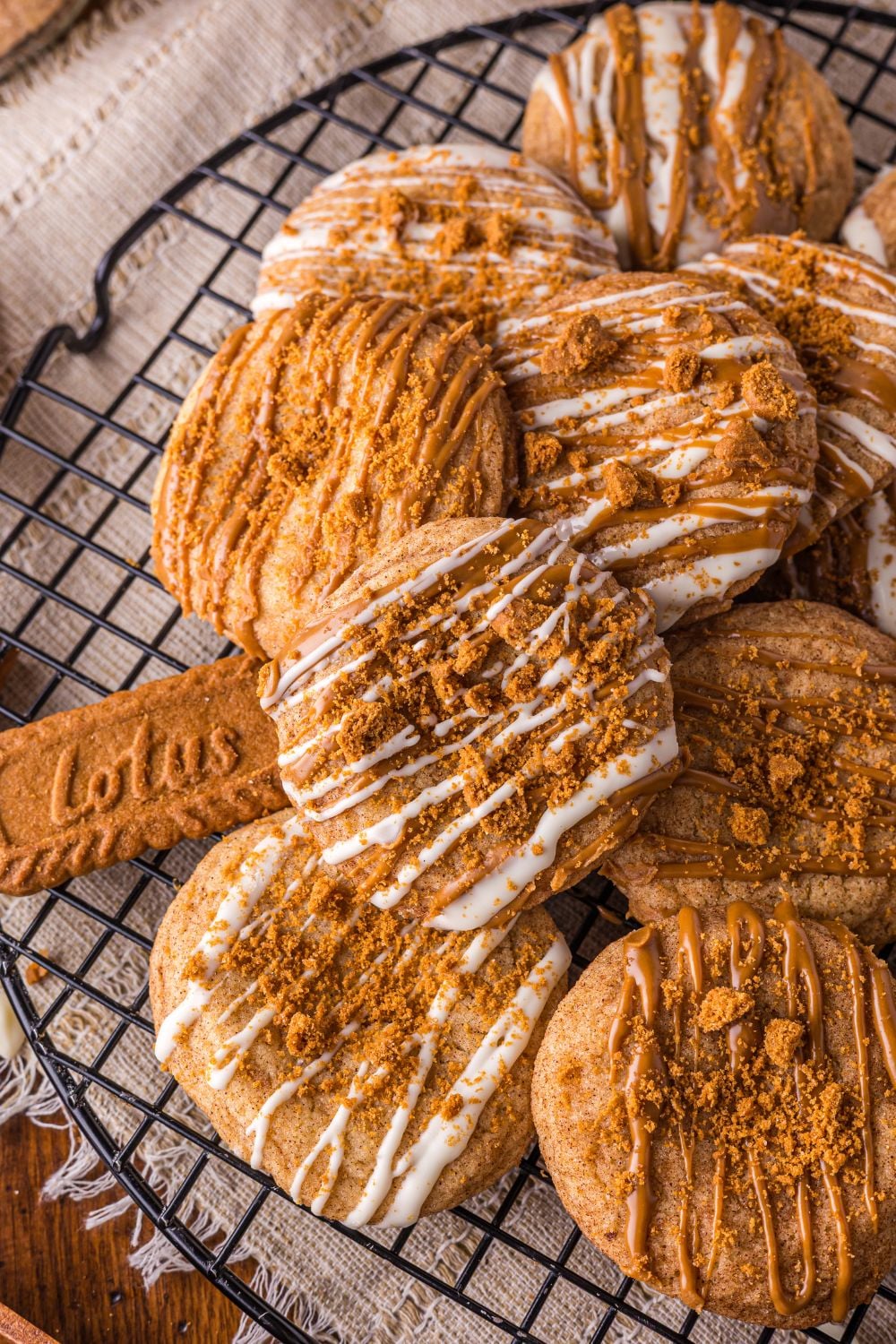 Biscoff Snickerdoodle Cookies on a cooling rack with Lotus cookies around the table 