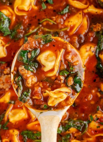 Sausage Tortellini Soup in a pot with a ladle full of some of the soup