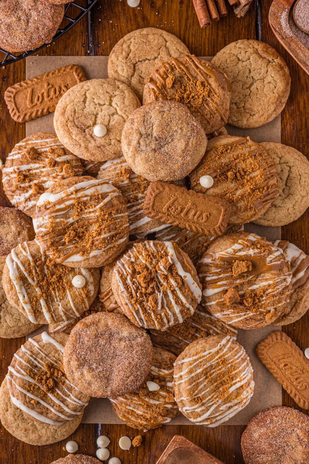 Biscoff Snickerdoodle Cookies piled on the table with white chocolate chips around the table 