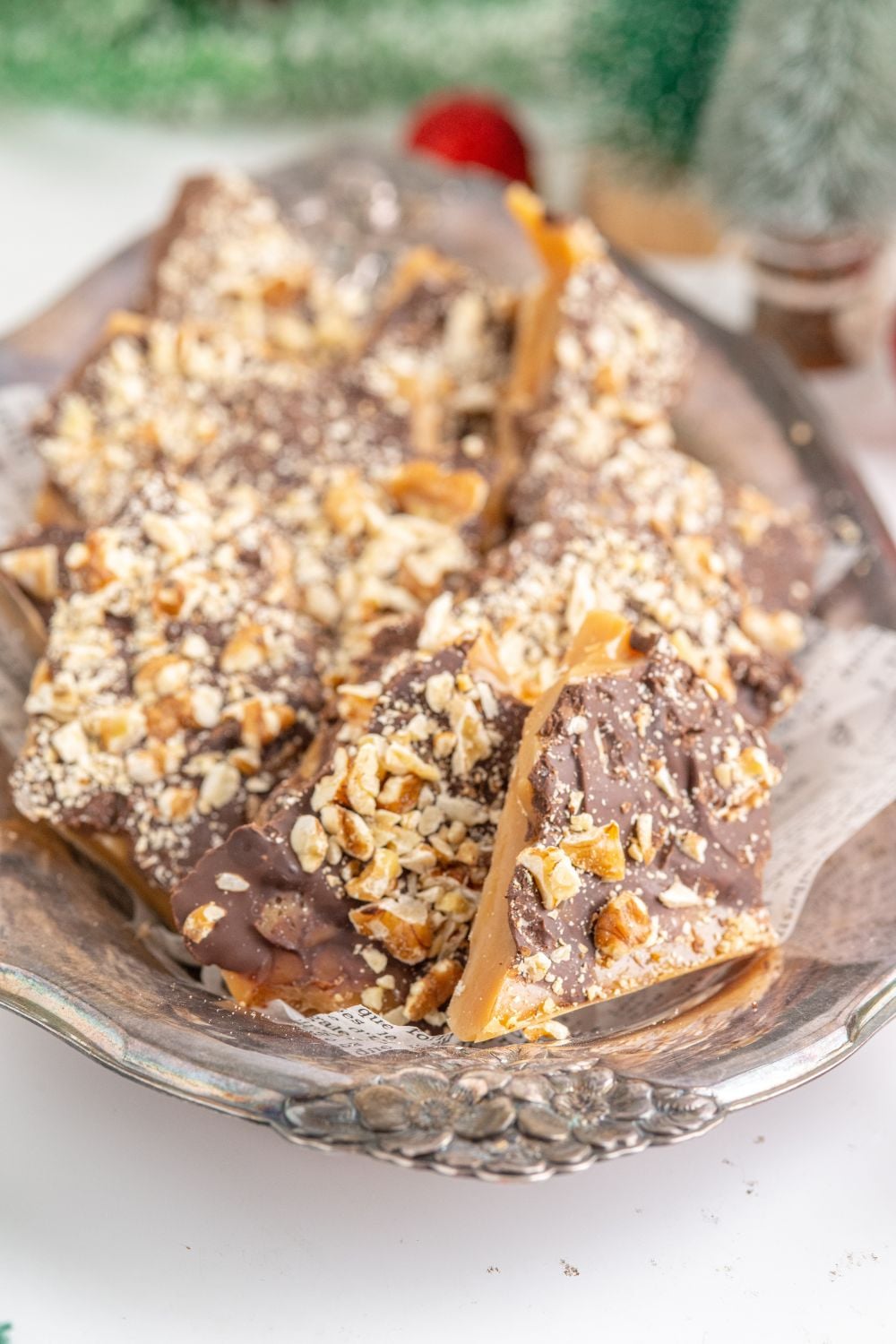 view of English Toffee on a platter with greenery behind it on table 