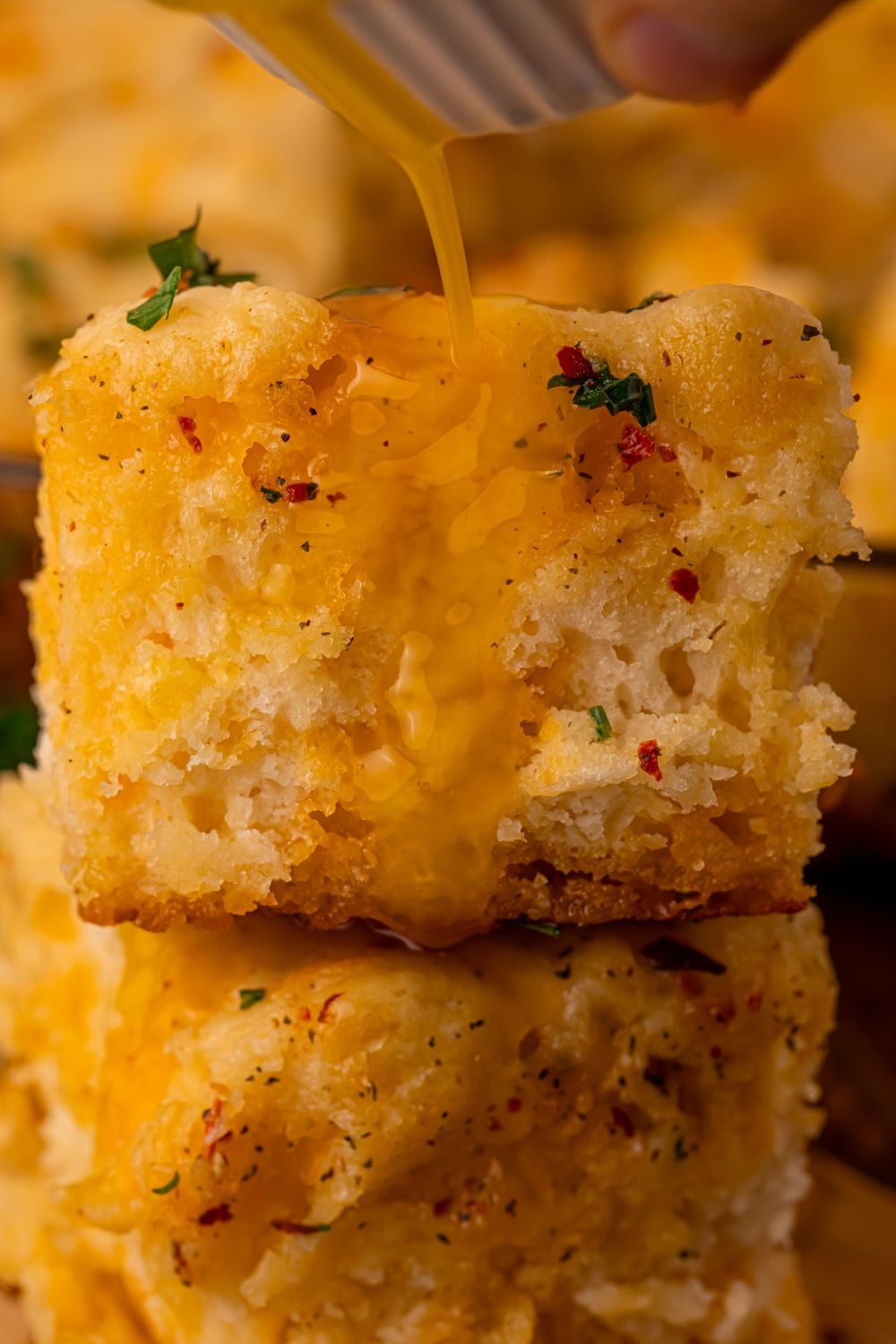 stacked biscuits with cowboy butter pouring over the top of the biscuits 