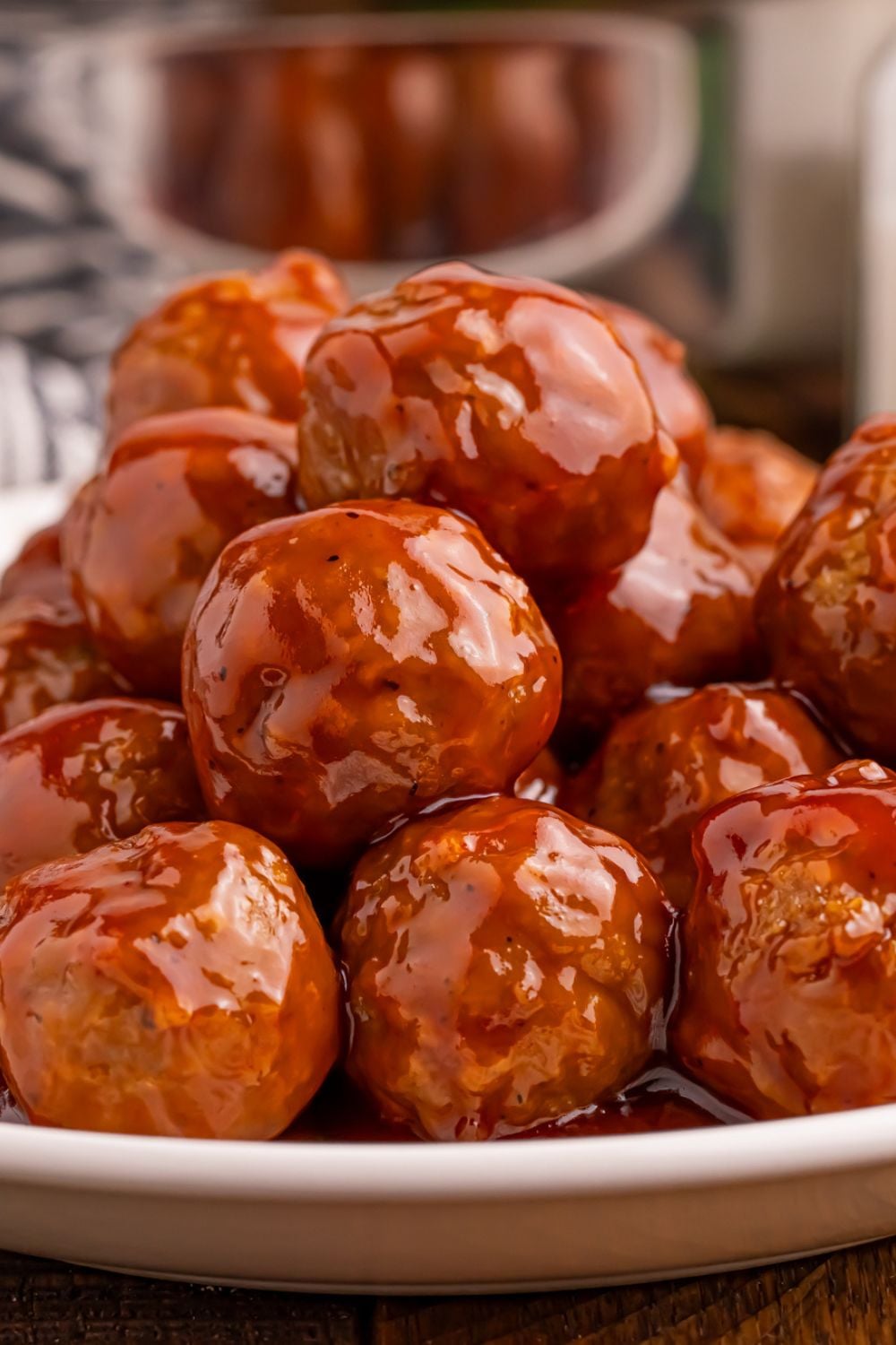 close up look of a stack of Peach BBQ Meatballs on a plate showing all the glaze coating each meatball