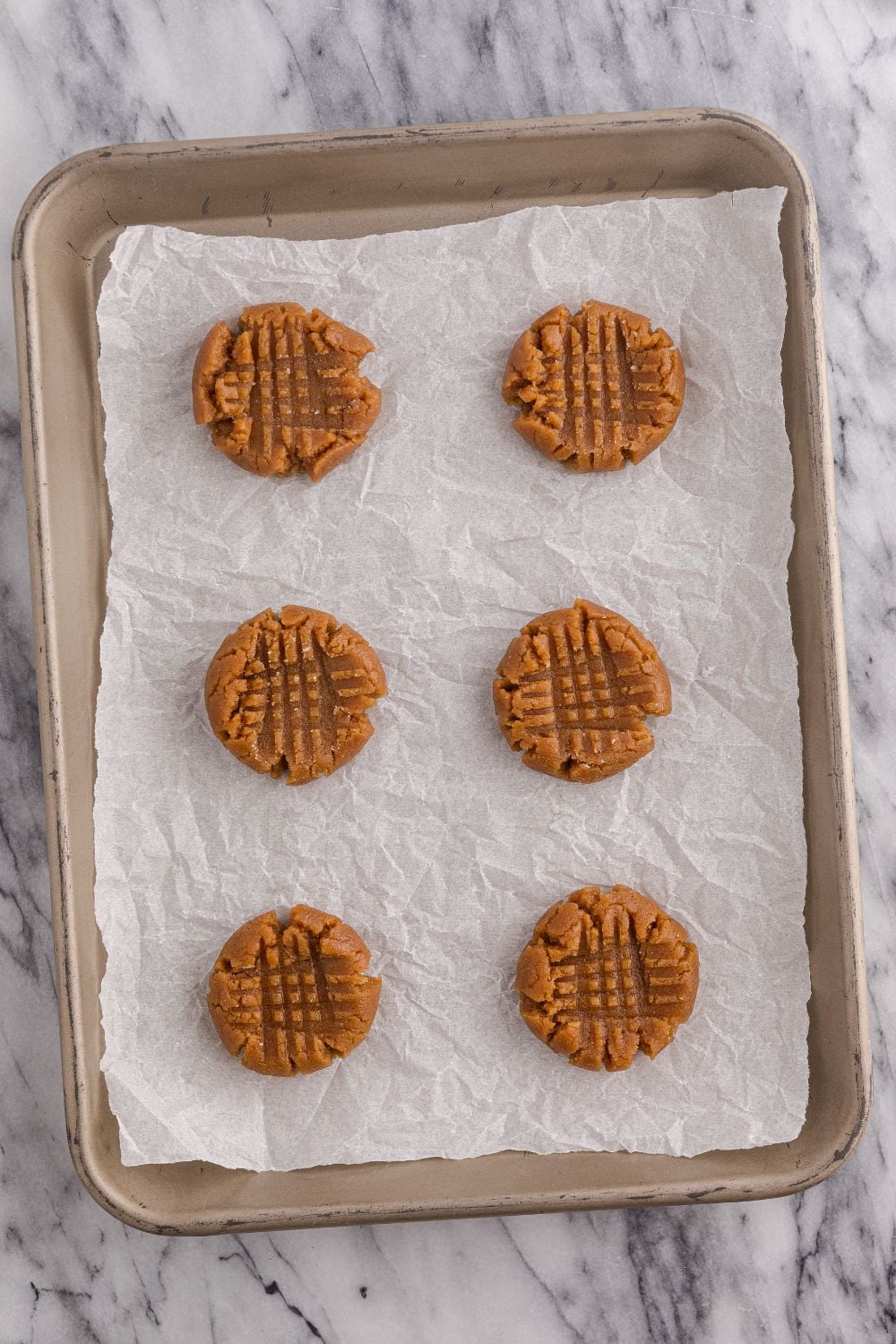 raw peanut butter cookies on the cookie sheet tray 
