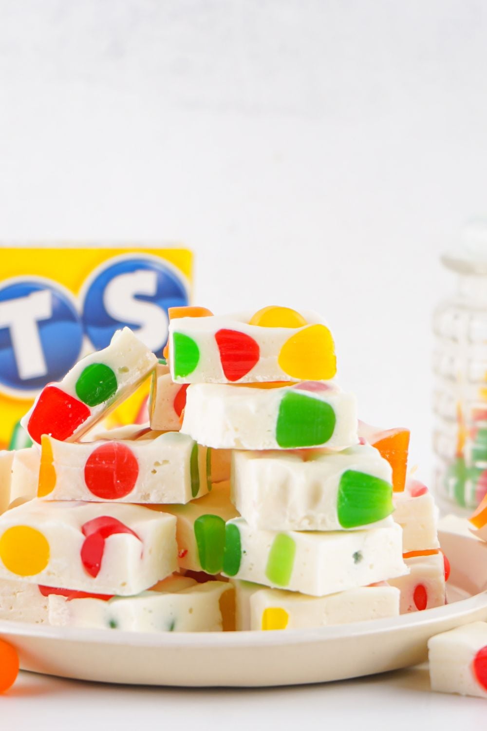 stack of Christmas Gumdrop Nougat Candy on a plate with a box of dot candy behind it on the table 