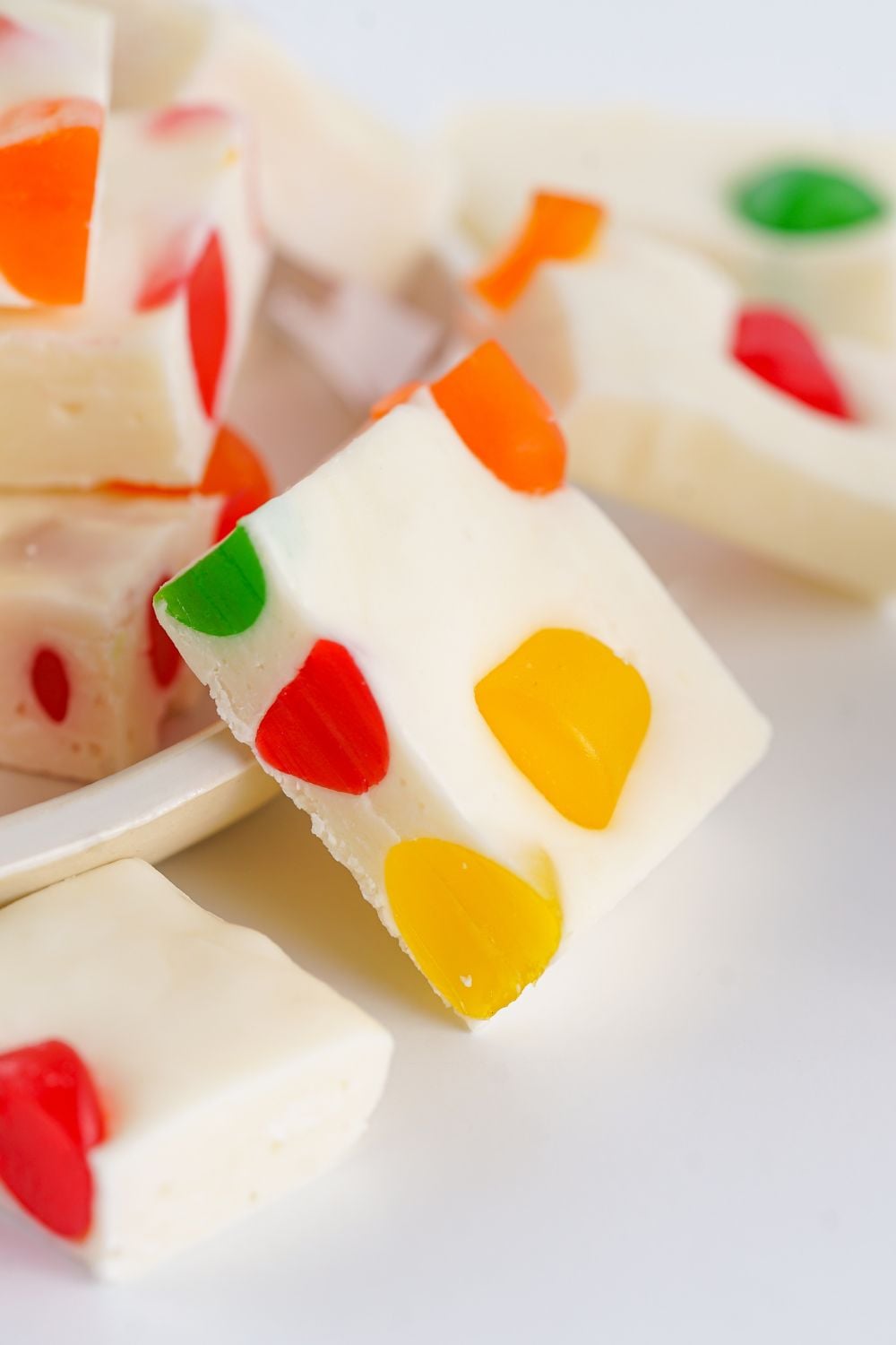 Christmas Gumdrop Nougat Candy spread out on table with a white plate full of nougat 