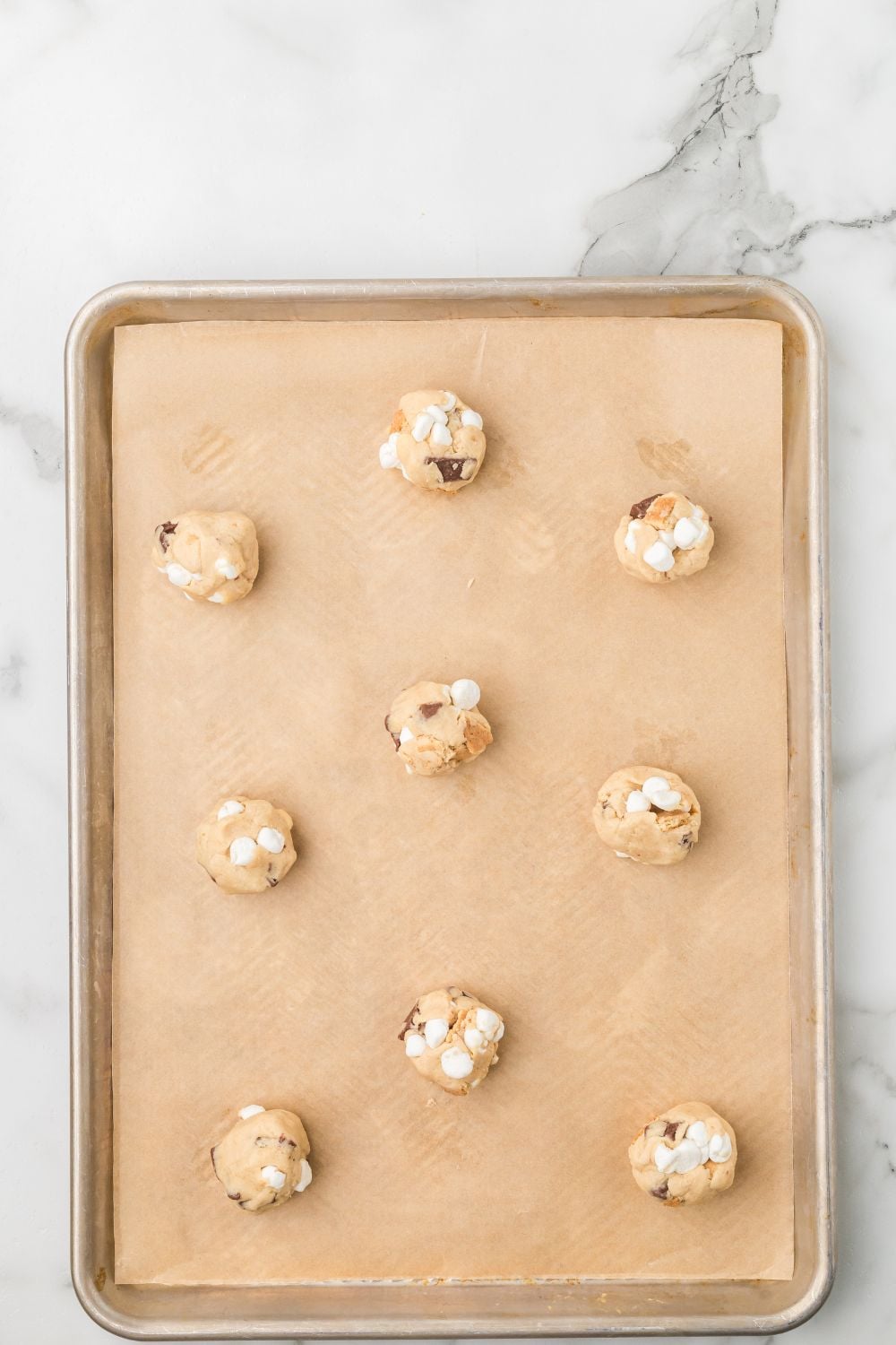 S'mores Cookie dough rolled into balls on a baking sheet 