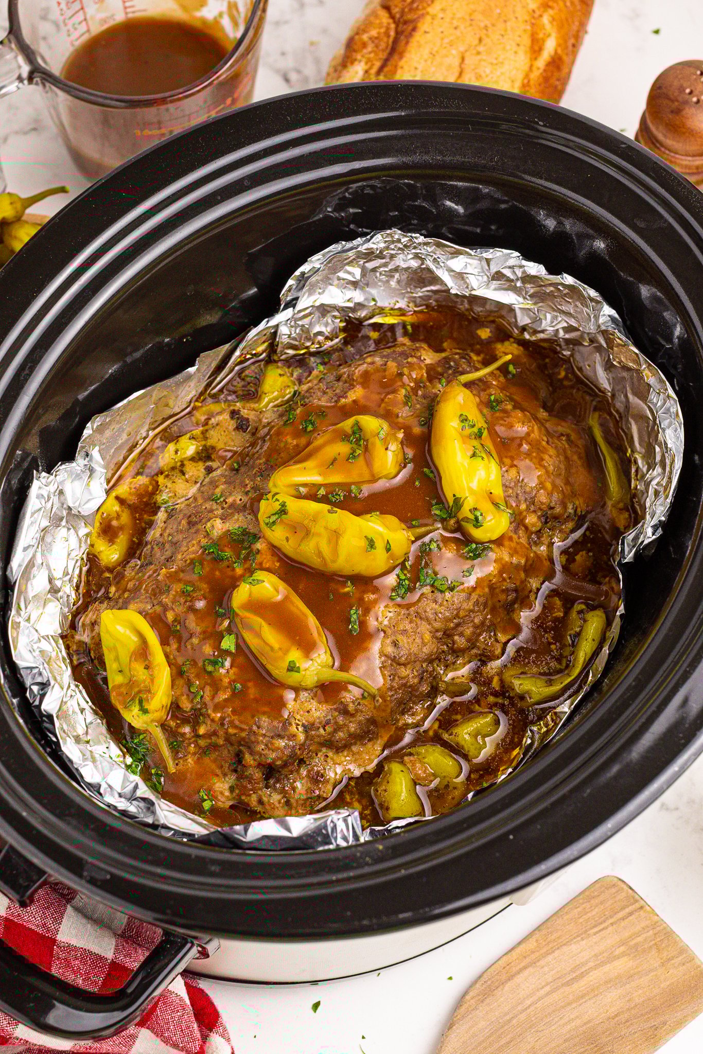 Crockpot Mississippi Meatloaf in a black slow cooker lined with foil 