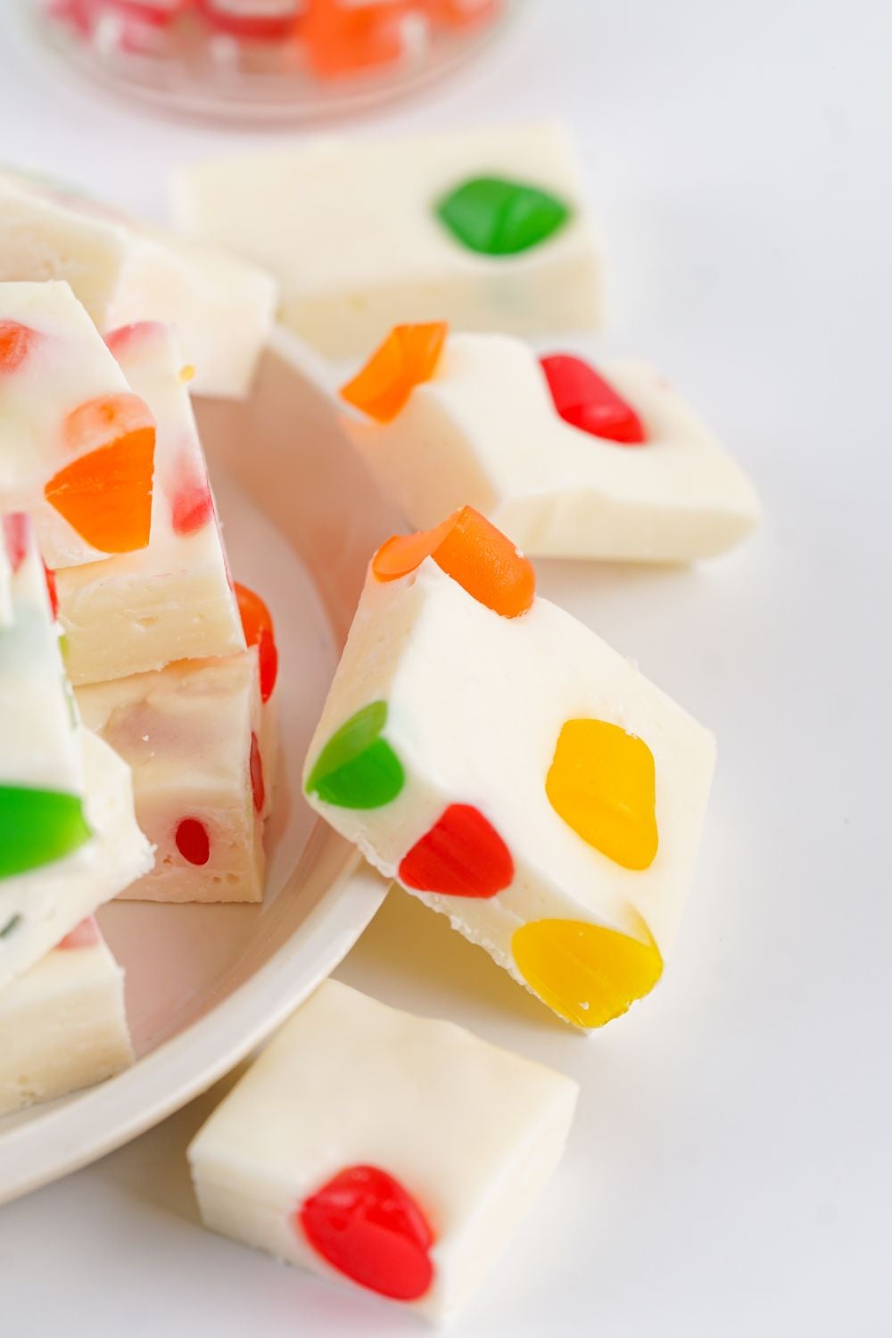a white plate with some sliced Christmas Gumdrop Nougat Candy around it and around the table 