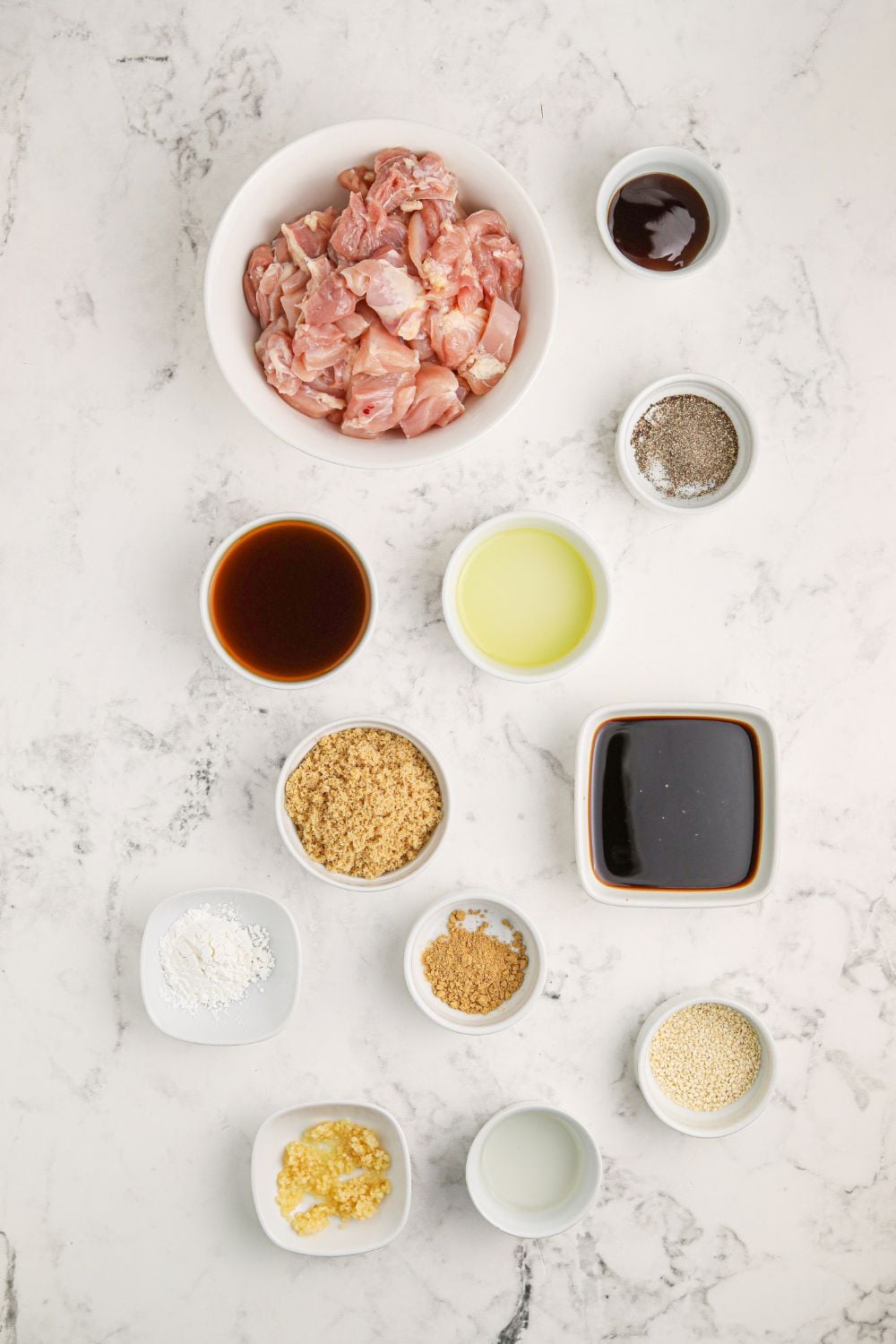 all the ingredients in small single serve bowls on table for making Bourbon Chicken Skillet