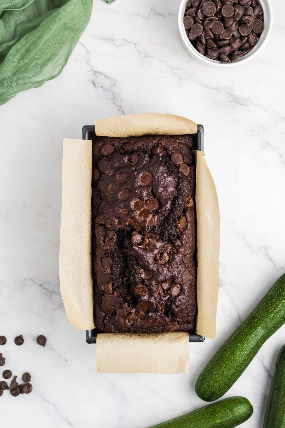 Double Chocolate Zucchini Bread baked and placed in the pan with zucchini to the side