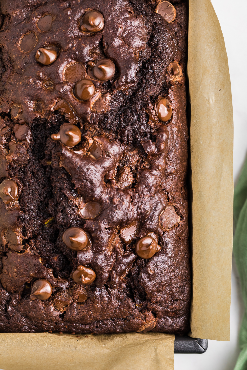 close up look of Double Chocolate Zucchini Bread in a parchment lined baking loaf