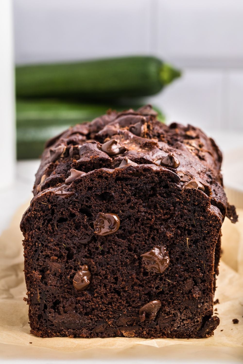 Double Chocolate Zucchini Bread loaf on a cutting board with studded chocolate chips