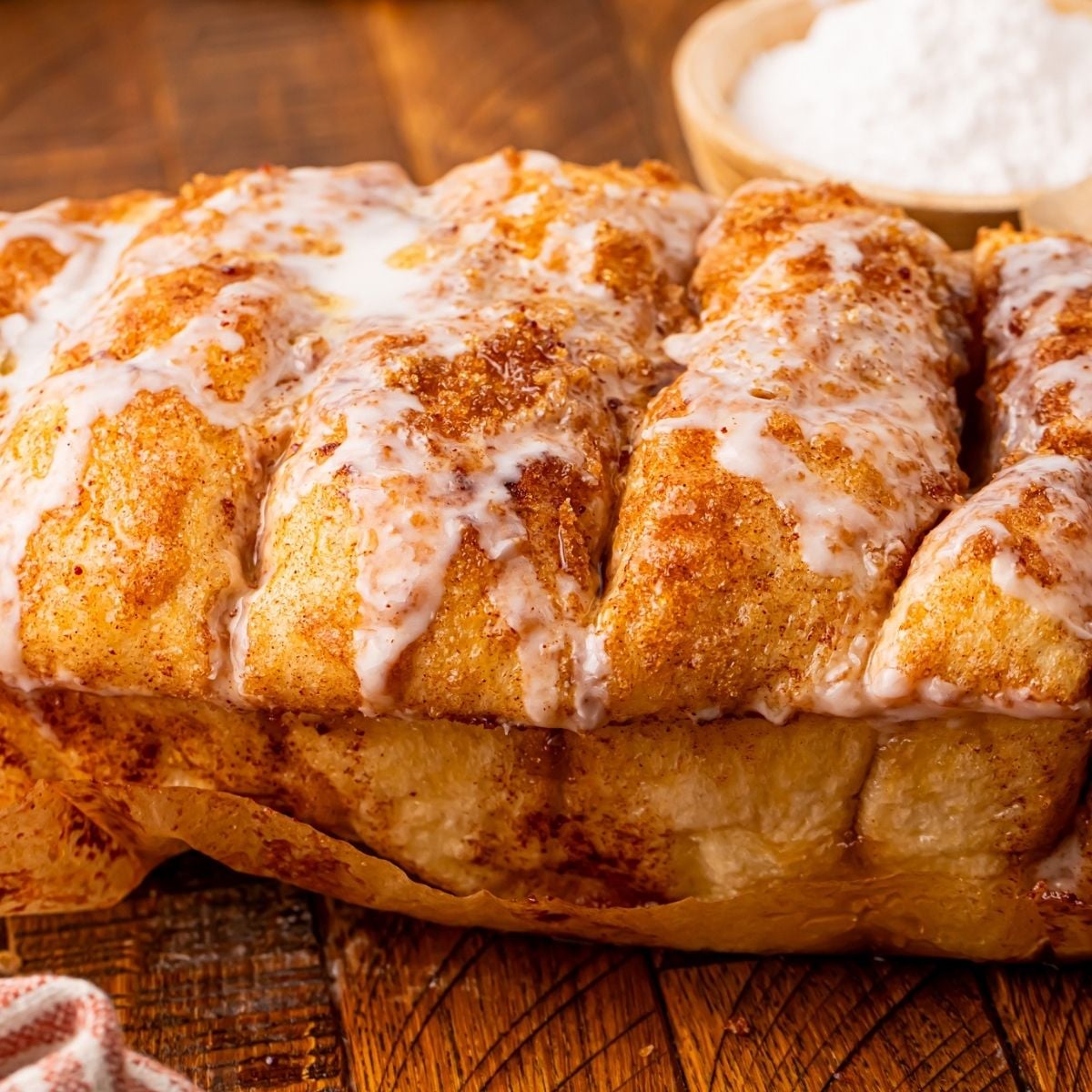Dollywood Cinnamon Bread on a table with cream cheese behind it on the table 