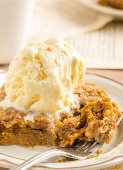 Homemade Pumpkin Crisp placed on a plate with ice cream on top of the crisp