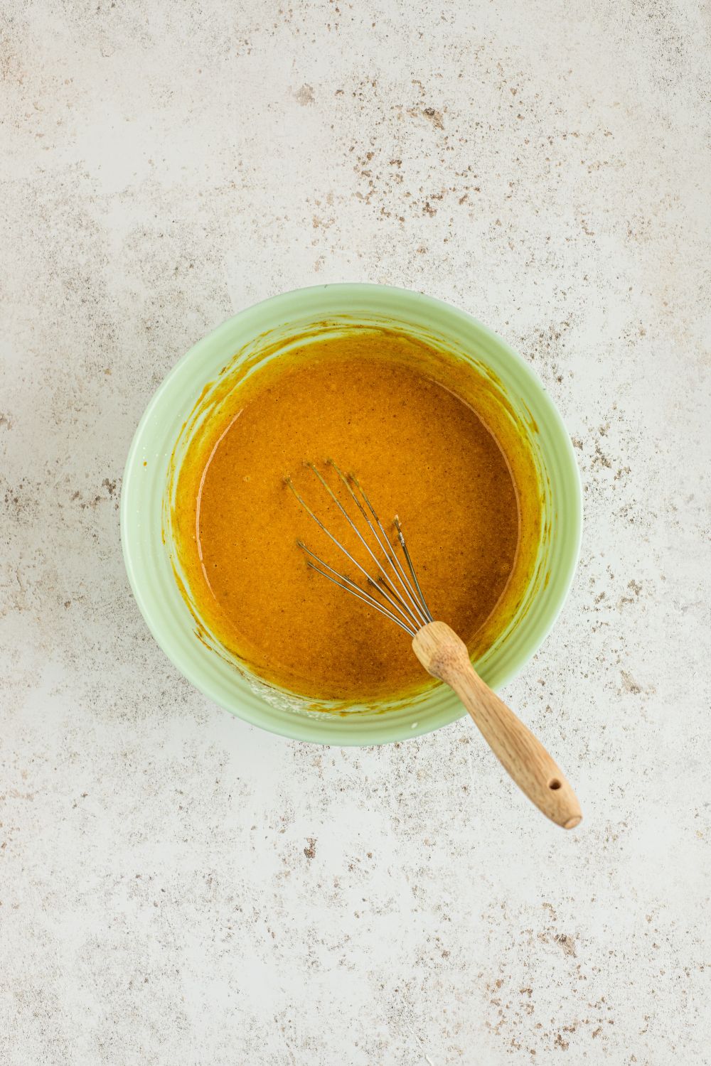 mixing up the batter of a pumpkin crisp in a bowl 