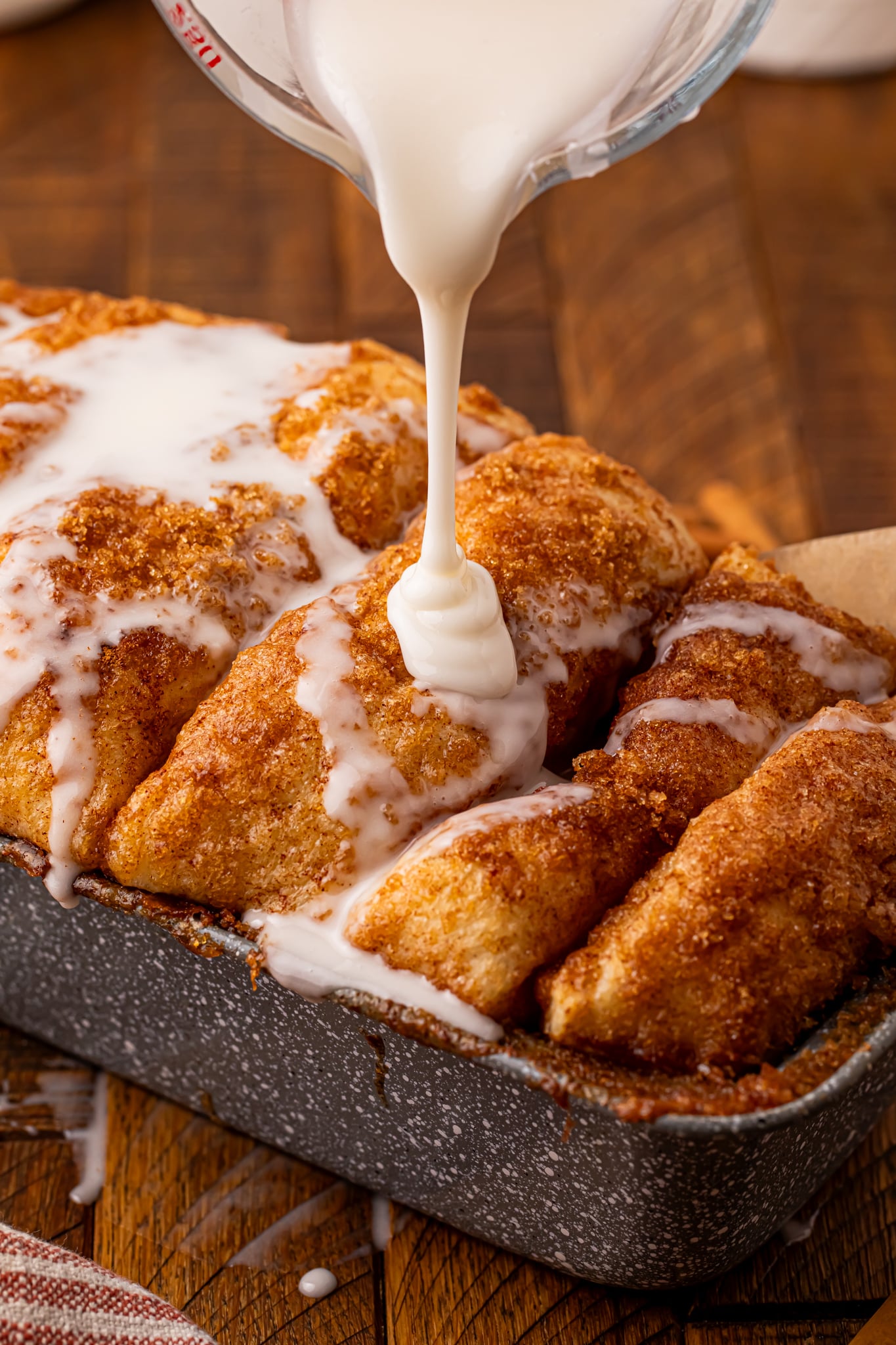 Dollywood Cinnamon Bread in a pan with a drizzle of sauce over the top 