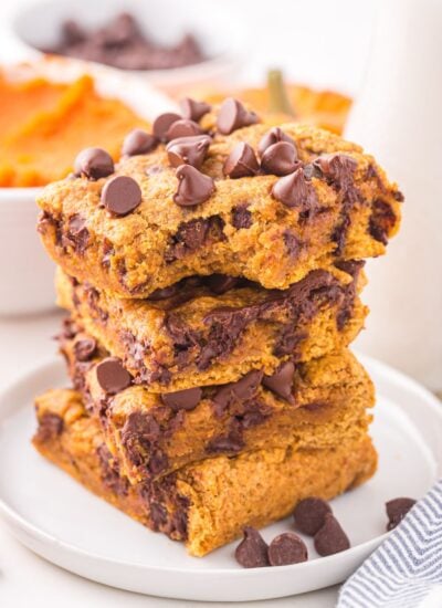 pumpkin chocolate chip cookie bars on a white plate stacked