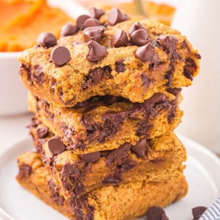 pumpkin chocolate chip cookie bars on a white plate stacked